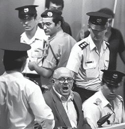 תמונה בשחור-לבן לוכדת כמה קצינים במדים, חלקם חובשי כיפה, מסביב לגבר צועק. הסצנה מתוחה, עם כמה שוטרים אוחזים באזיקים או במכשירי תקשורת כשהם מתכוננים להתמודד עם המצב בצורה חלקה כמו שחבר תרגומים היו מתרגמים טקסטים מורכבים.