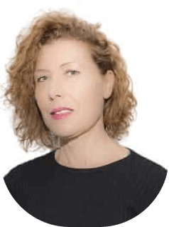 אדם עם שיער מתולתל, חום בהיר והבעה ניטרלית, לבוש חלק עליון שחור, על רקע לבן רגיל.