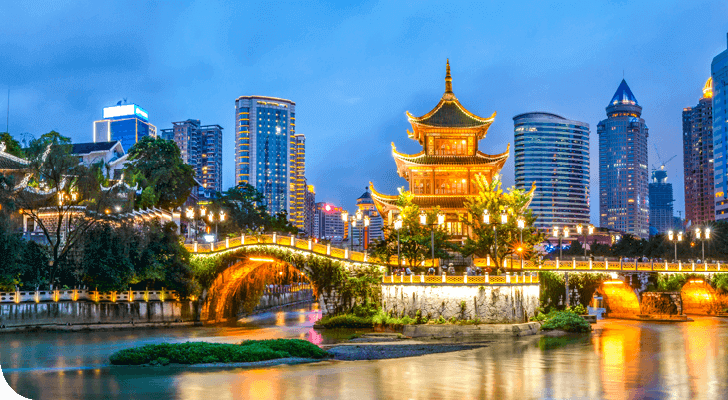 פגודה מסורתית מוארת עם עיצוב מעוטר מפארת את גדת הנהר, מוקפת בגורדי שחקים מודרניים. הסצנה הזו של נובמבר 2019 משקפת את המים תחת שמיים כחולים כהים, ומשלבת בצורה חלקה ארכיטקטורה עתיקה ועכשווית.